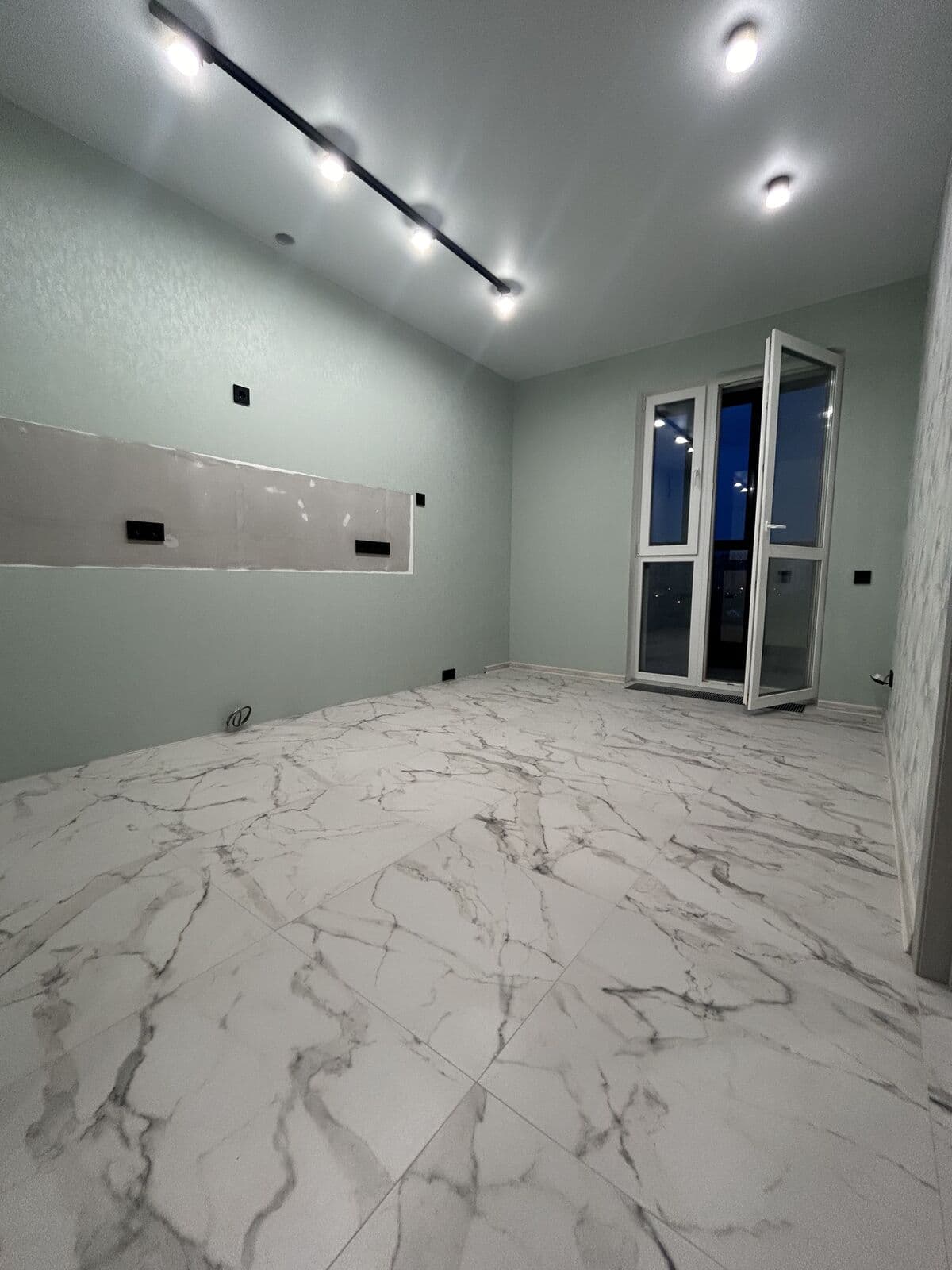 Гостиная на финальном этапе — мраморный пол, трековые споты, балкон