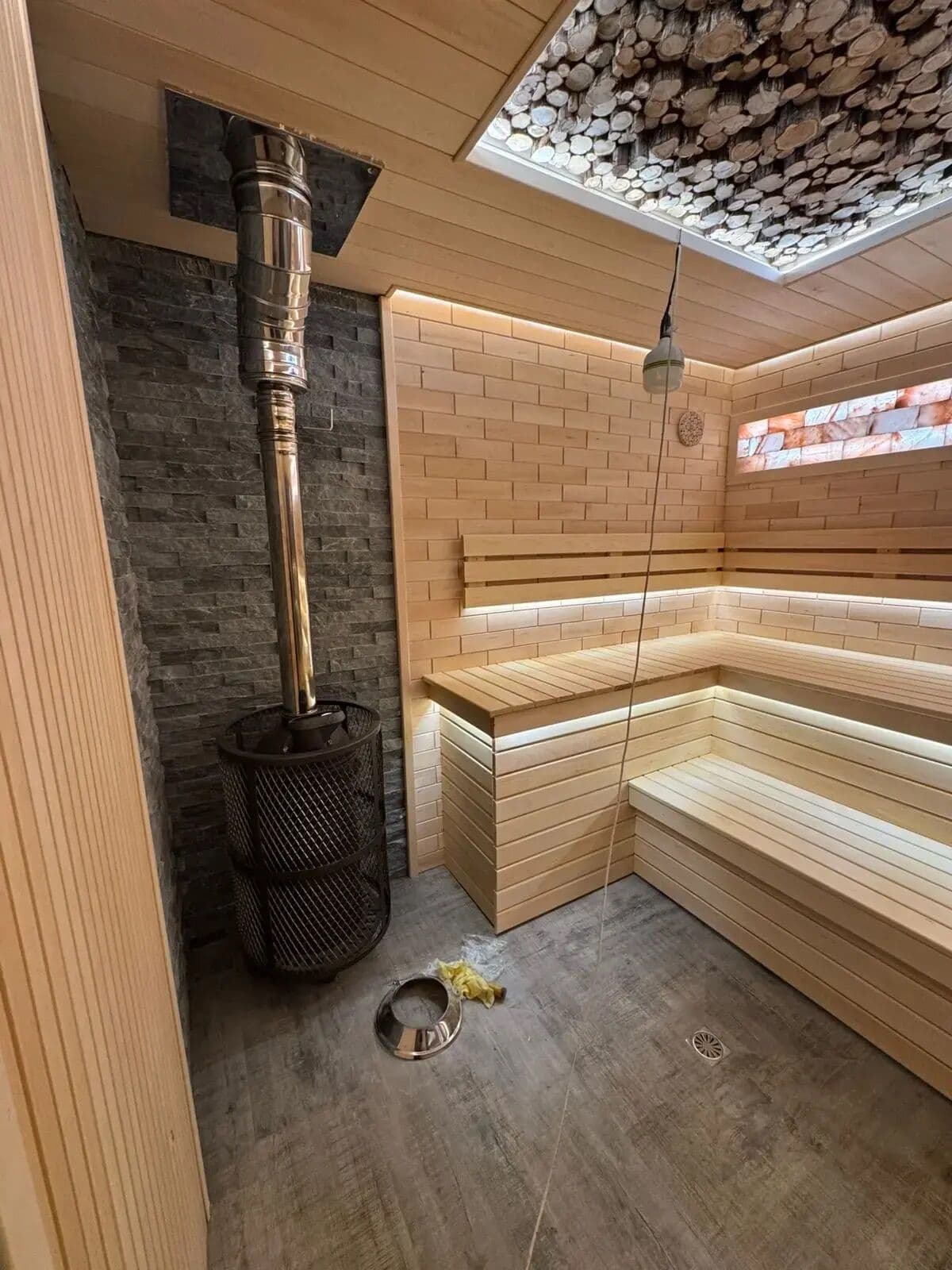 Парная — печь с дымоходом на каменной стене, полки из липы с подсветкой, потолок из спилов