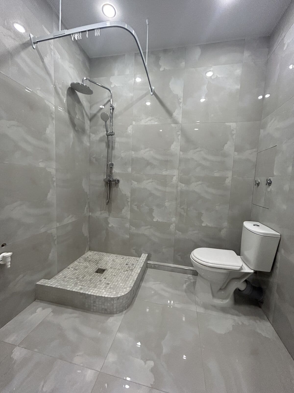 Ванная с серой плиткой — душевой поддон, унитаз, споты