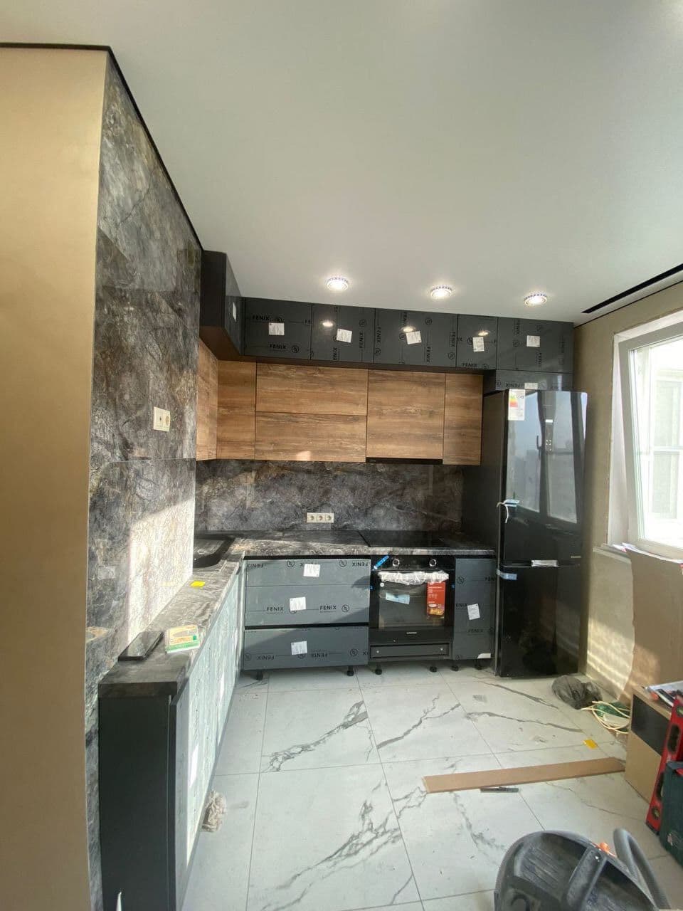 Общий вид кухни с окном — нижние и верхние секции, холодильник